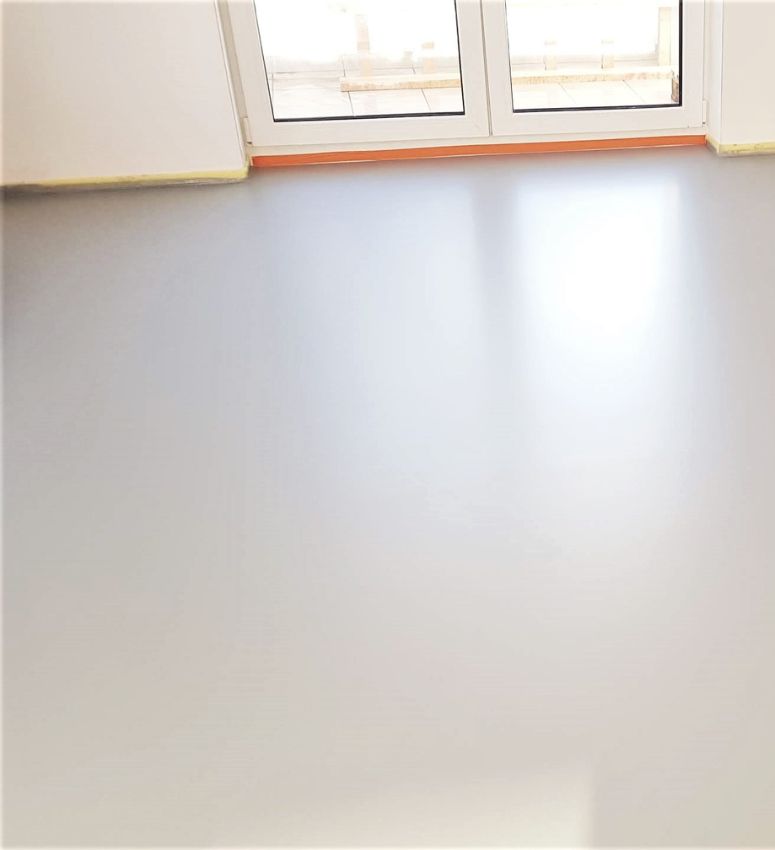 szara posadzka z zywicy poliuretanowej w pokoju